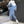 Man in blauw-wit trainingspak met capuchon en witte sneakers, moderne sportieve kleding, industriële achtergrond, streetwear mode.