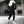 Man in zwart-wit sportkleding met capuchon en sneakers in moderne kledingwinkel. Stijlvolle herenkleding, urban fashion, sportieve outfit.