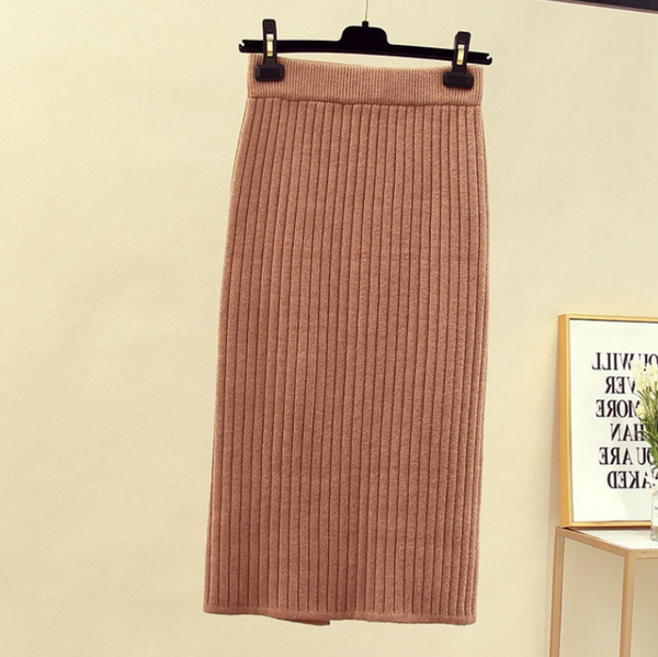 Bruine geribbelde midi-rok, hangend aan een hanger, perfect voor herfstmode. Stijlvolle dameskleding, comfortabel en trendy ontwerp.
