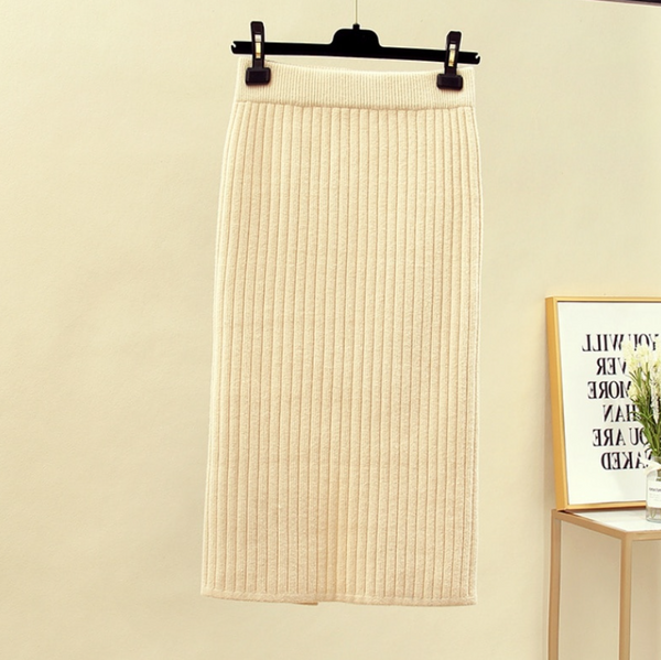 Crèmekleurige geribbelde midi-rok, elegant en stijlvol, perfect voor herfstmode. Hangend aan een zwarte hanger tegen een neutrale achtergrond.