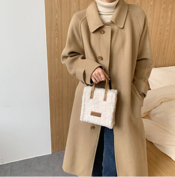 Vrouw in beige wollen jas met knopen, draagt een witte pluchen handtas. Stijlvolle wintermode, casual outfit, trendy accessoires.