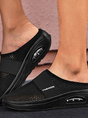 Zwarte ademende mesh slippers met verhoogde zool en luchtkussen, comfortabele instappers voor dames, mode en casual schoeisel.