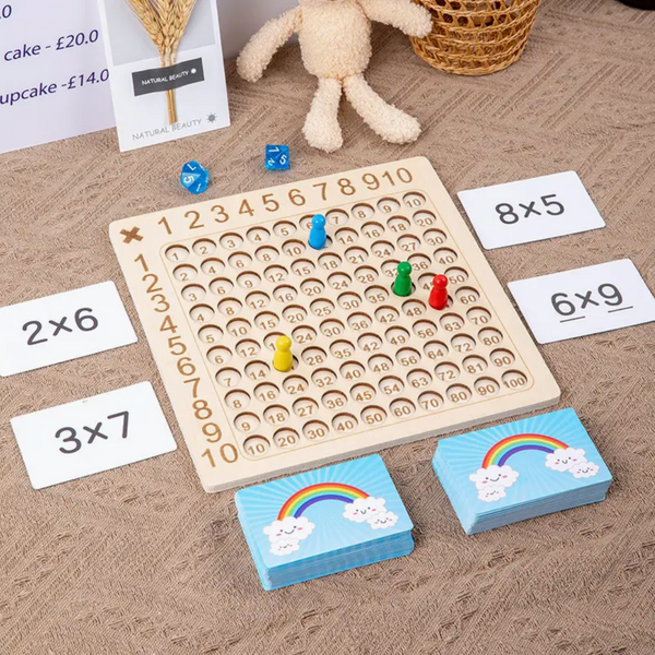 Houten rekenspelbord met cijfers en pionnen, omringd door kaarten met vermenigvuldigingsopgaven. Educatief speelgoed voor kinderen, wiskunde leren.