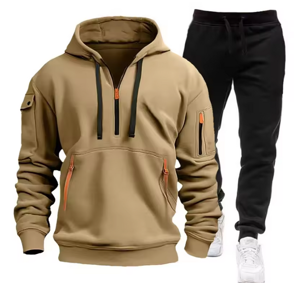 Beige hoodie met zwarte trekkoorden en zakken, gecombineerd met zwarte joggingbroek en witte sneakers. Comfortabele herenkleding set.