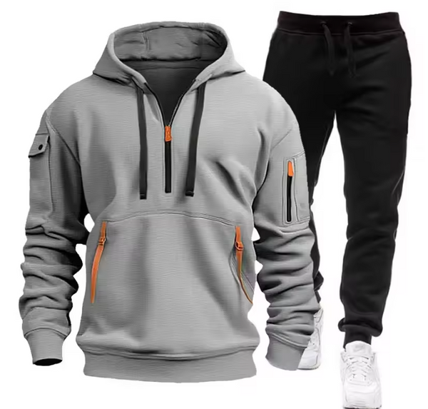 Grijze hoodie met oranje ritsen en zwarte joggingbroek, sportieve herenkleding, comfortabele casual outfit, ideaal voor dagelijks gebruik.