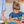 Kleuter in blauwe jurk snijdt groenten met kindvriendelijk mes in keuken. Gezonde voeding, koken met kinderen, educatieve activiteiten.