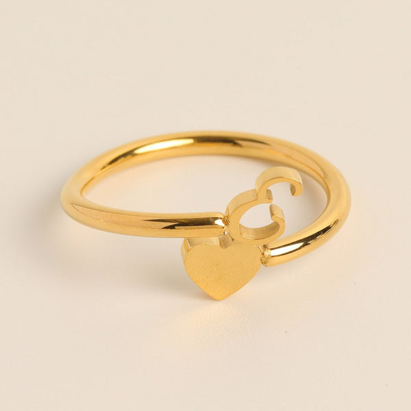 Gouden ring met hart- en ampersand-symbool, minimalistisch ontwerp, perfect als cadeau voor geliefden. Elegant sieraad voor dagelijks gebruik.