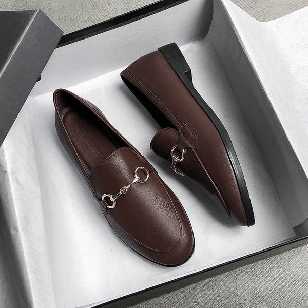 Bruine leren loafers met metalen gesp in een open schoenendoos, stijlvolle herenschoenen, casual en formeel, hoogwaardige afwerking.
