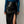 Vrouw in blauwe blouse en zwarte leren rok met hoge split. Modieuze dameskleding, elegante stijl, herfstmode.