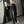 Vrouw in trendy zwarte wijde broek met witte strepen, crop top en pet poseert voor spiegel. Streetwear mode, casual outfit, moderne stijl.
