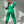 Vrouw in groene joggingpak poseert tegen witte achtergrond, modieuze sportkleding, comfortabele loungewear, trendy damesmode.