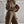 Vrouw in bruine oversized hoodie en joggingbroek met zakken, modieuze streetwear, comfortabele loungewear, minimalistisch interieur, urban stijl.