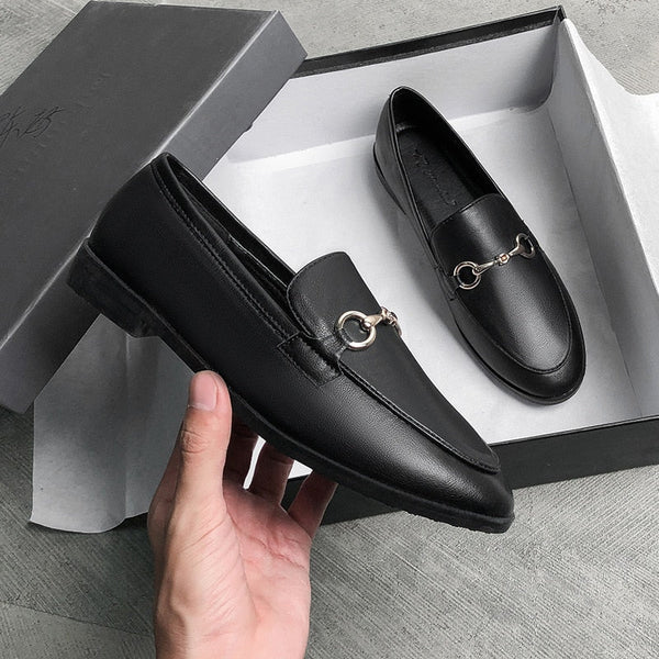 Zwarte leren loafers met metalen gesp, stijlvolle herenschoenen in open doos. Perfect voor formele gelegenheden en dagelijks gebruik.