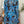 Vrouw in blauwe tropische bladeren jurk, rugaanzicht. Trendy zomerjurk, casual mode, tropisch patroon, stijlvolle dameskleding.