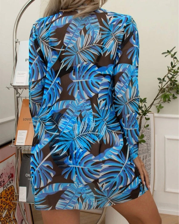 Vrouw in blauwe tropische bladeren jurk, rugaanzicht. Trendy zomerjurk, casual mode, tropisch patroon, stijlvolle dameskleding.
