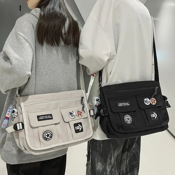 Twee crossbody tassen, één beige en één zwart, met patches en sleutelhangers. Ideaal voor casual mode en dagelijks gebruik. Unisex schoudertassen.