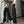 Vrouw in zwarte wijde broek en wit crop top voor spiegel, trendy streetwear mode, casual outfit, lange broek met rits, modeaccessoires.