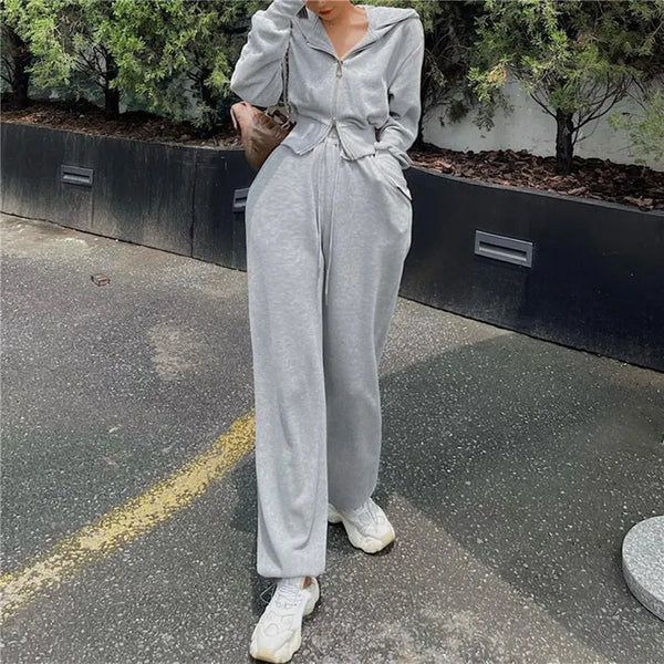 Grijze damesjumpsuit met capuchon, lange mouwen en zakken, casual streetwear, comfortabele pasvorm, ideaal voor dagelijks gebruik en sportieve stijl.
