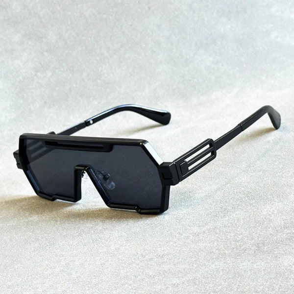 Zwarte futuristische zonnebril met rechthoekige glazen en geometrisch montuur op grijze achtergrond. Trendy unisex accessoire voor modebewuste stijl.