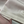 Close-up van een roze en witte poloshirtstof met halve rits, textuur en stiksel zichtbaar. Hoogwaardige sportkleding, ademend materiaal.