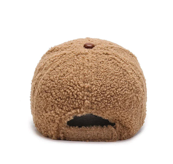 Bruine teddy stof pet, achterkant. Zachte, pluizige textuur, trendy accessoire. Perfect voor casual mode en winterse outfits.