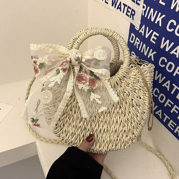 Rieten handtas met geborduurde bloemenstrik, trendy modeaccessoire, zomerse strandtas, stijlvolle dameshandtas, boho-chic stijl.
