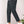 Man draagt zwarte chino broek en witte sneakers, casual mode, zijaanzicht. Comfortabele herenkleding, moderne stijl, dagelijkse outfit.