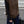 Bruine gebreide spencer met dubbele rij knopen, gedragen over een zwarte trui. Modieuze herfstkleding, casual stijl, straatmode.