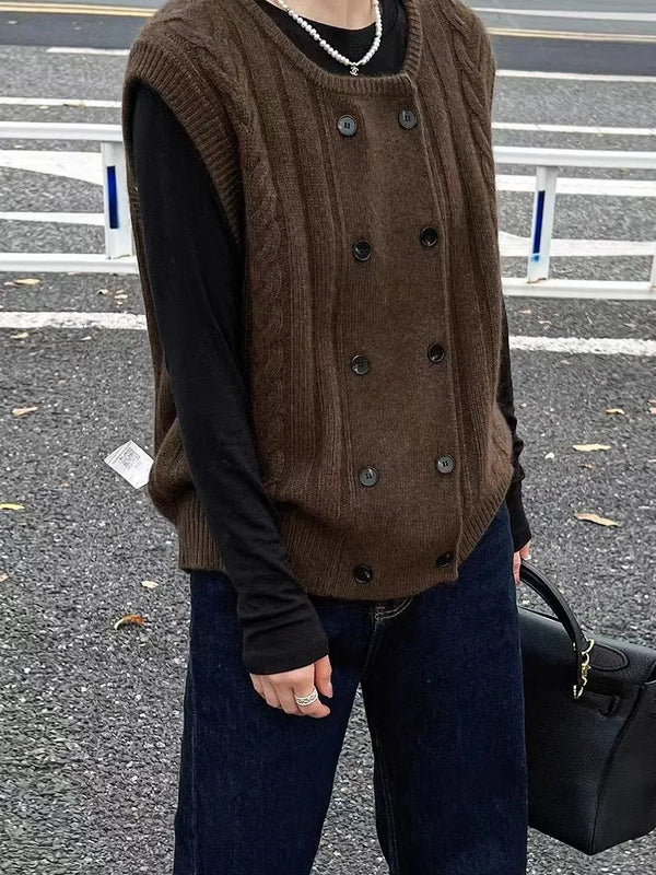 Bruine gebreide spencer met dubbele rij knopen, gedragen over een zwarte trui. Modieuze herfstkleding, casual stijl, straatmode.