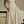 Vrouw in elegante beige strapless jurk met volle rok, staand naast klassieke auto. Mode, vintage stijl, avondkleding, retro glamour.