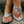 Zilveren sandalen met bloemenstrass en witte nagellak op stenen achtergrond. Trendy damesmode, zomerschoenen, elegante accessoires.