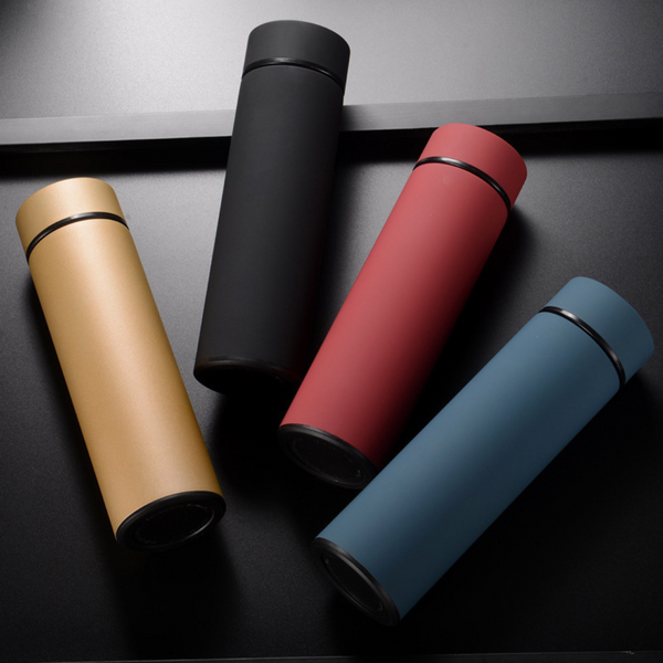 Vier slimme thermosflessen in zwart, rood, goud en blauw op een donkere achtergrond. Ideaal voor temperatuurbehoud en hydratatie onderweg.