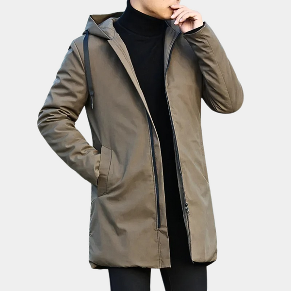 Man in een lange, bruine herenjas met capuchon en ritssluiting, hand in zak. Stijlvolle winterjas voor heren, ideaal voor casual en formele gelegenheden.