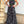 Zwarte maxi-jurk met witte abstracte lijnen, mouwloos en halternek, perfect voor zomerse evenementen en casual chique gelegenheden.