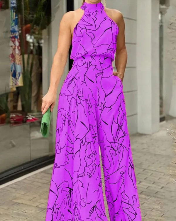 Vrouw in felroze jumpsuit met abstracte zwarte lijnen, staand voor een moderne winkel. Ze houdt een groene clutch vast. Trendy mode, zomeroutfit.