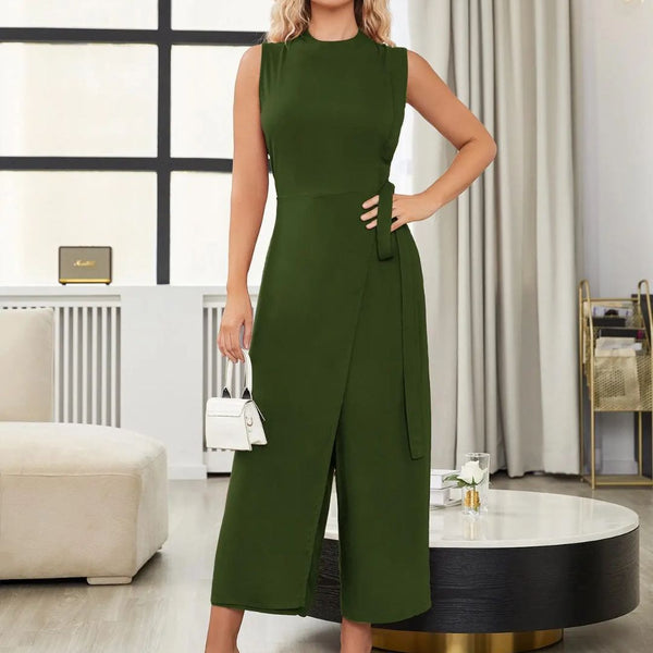 Vrouw in stijlvolle groene jurk met ceintuur, staand in moderne woonkamer. Elegante mode, trendy dameskleding, interieurdesign.