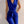 Vrouw in stijlvolle blauwe jumpsuit met gouden knopen en ceintuur, modieuze outfit, elegante dameskleding, trendy modeaccessoires.