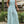 Vrouw in stijlvolle, lichtblauwe jumpsuit met abstracte witte lijnen, buiten gefotografeerd. Trendy damesmode, zomeroutfit, casual chic.