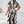 Vrouw in zwart-witte, abstracte printjurk, rugaanzicht. Trendy damesmode, elegante stijl, moderne kleding. Perfect voor casual en formele gelegenheden.