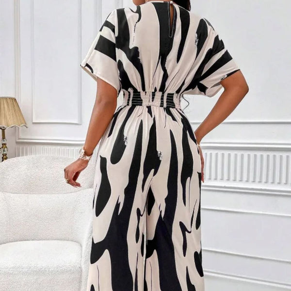 Vrouw in zwart-witte, abstracte printjurk, rugaanzicht. Trendy damesmode, elegante stijl, moderne kleding. Perfect voor casual en formele gelegenheden.