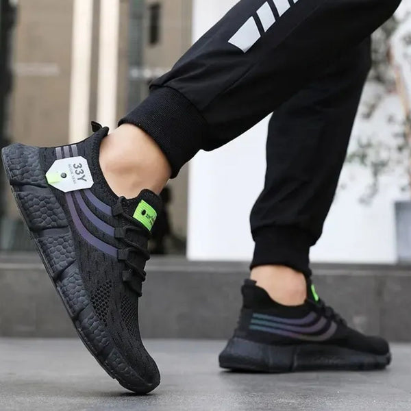 Zwarte sportschoenen met groene accenten, gedragen door persoon in zwarte joggingbroek. Moderne hardloopschoenen, comfortabel en stijlvol ontwerp.