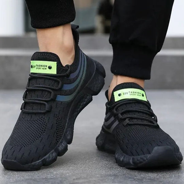 Zwarte sportschoenen met groene accenten, ademend mesh, comfortabele zool, ideaal voor hardlopen en fitness. Stijlvolle en functionele sneakers.