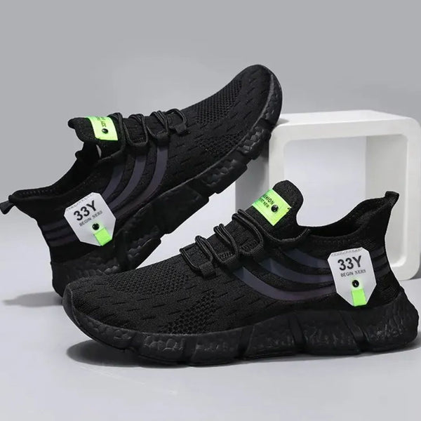 Zwarte sportschoenen met groene accenten, ademend mesh, lichtgewicht zool, geschikt voor hardlopen en fitness. Trendy en comfortabel schoeisel.