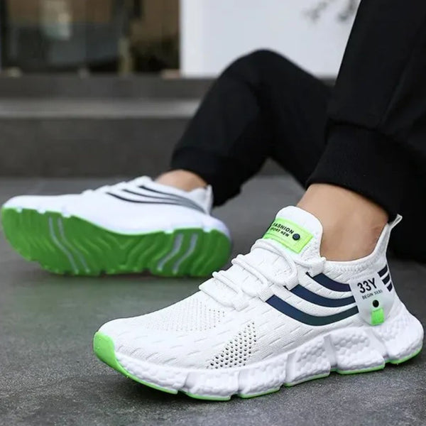 Witte sportschoenen met groene zool, ademend mesh, en blauwe strepen. Ideaal voor hardlopen en fitness. Comfortabele en modieuze sneakers.