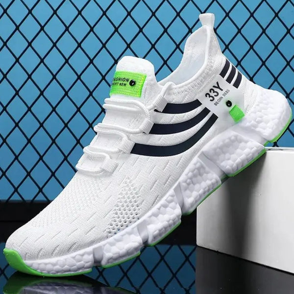 Witte sportschoen met zwarte strepen en groene accenten, ademend mesh bovenwerk, dikke zool, geschikt voor hardlopen en casual gebruik.
