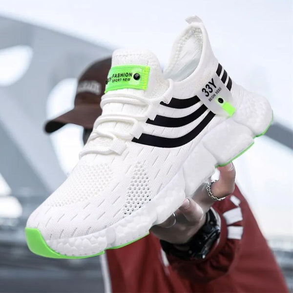 Witte sportschoen met zwarte strepen en groene accenten, ademend mesh, comfortabele zool, ideaal voor hardlopen en casual mode.