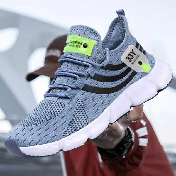 Blauwe sportschoen met zwarte strepen, ademend mesh bovenwerk, witte zool en groene accenten. Moderne hardloopschoen voor heren.