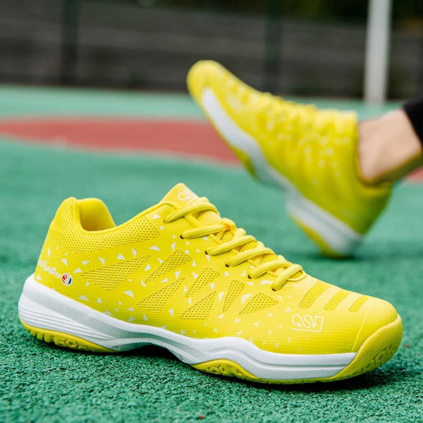 Gele sportschoenen op tennisbaan, ademend mesh, lichtgewicht ontwerp, ideaal voor hardlopen en tennis. Comfortabele pasvorm, duurzame zool.