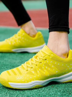 Gele tennisschoenen op tennisbaan, sportieve sneakers voor heren, comfortabele hardloopschoenen, ademend ontwerp, duurzame zolen.
