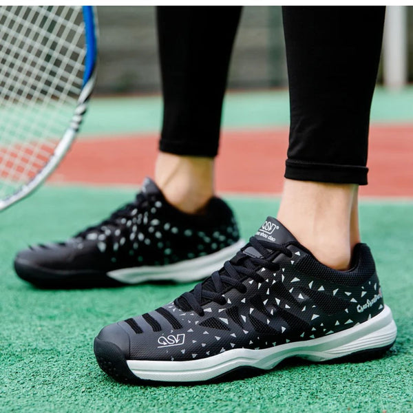 Tennisschoenen met zwart-wit geometrisch patroon op tennisbaan, naast racket. Comfortabele sportschoenen voor optimale prestaties.